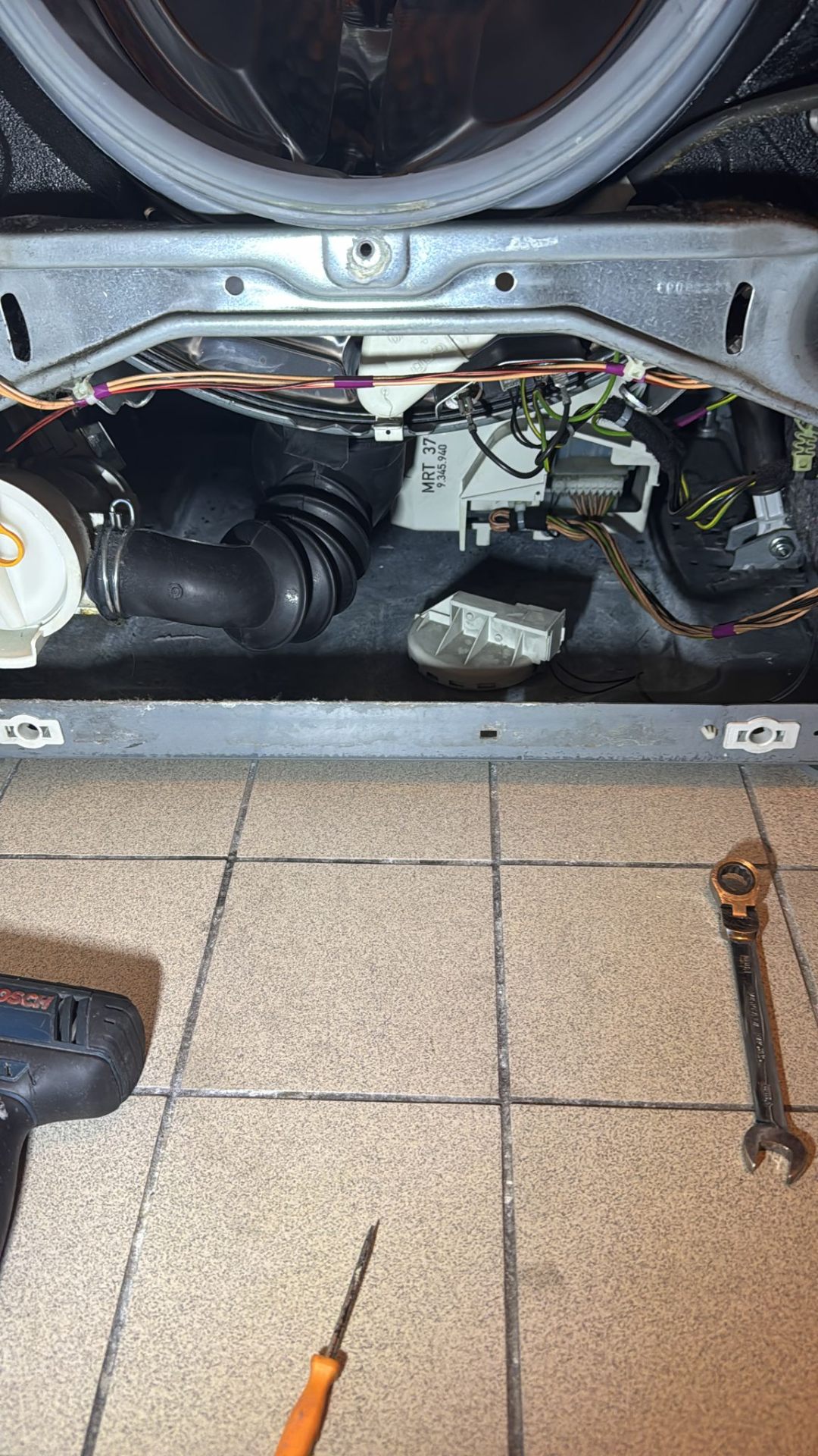 Monteur werkt aan binnenwerk wasmachine